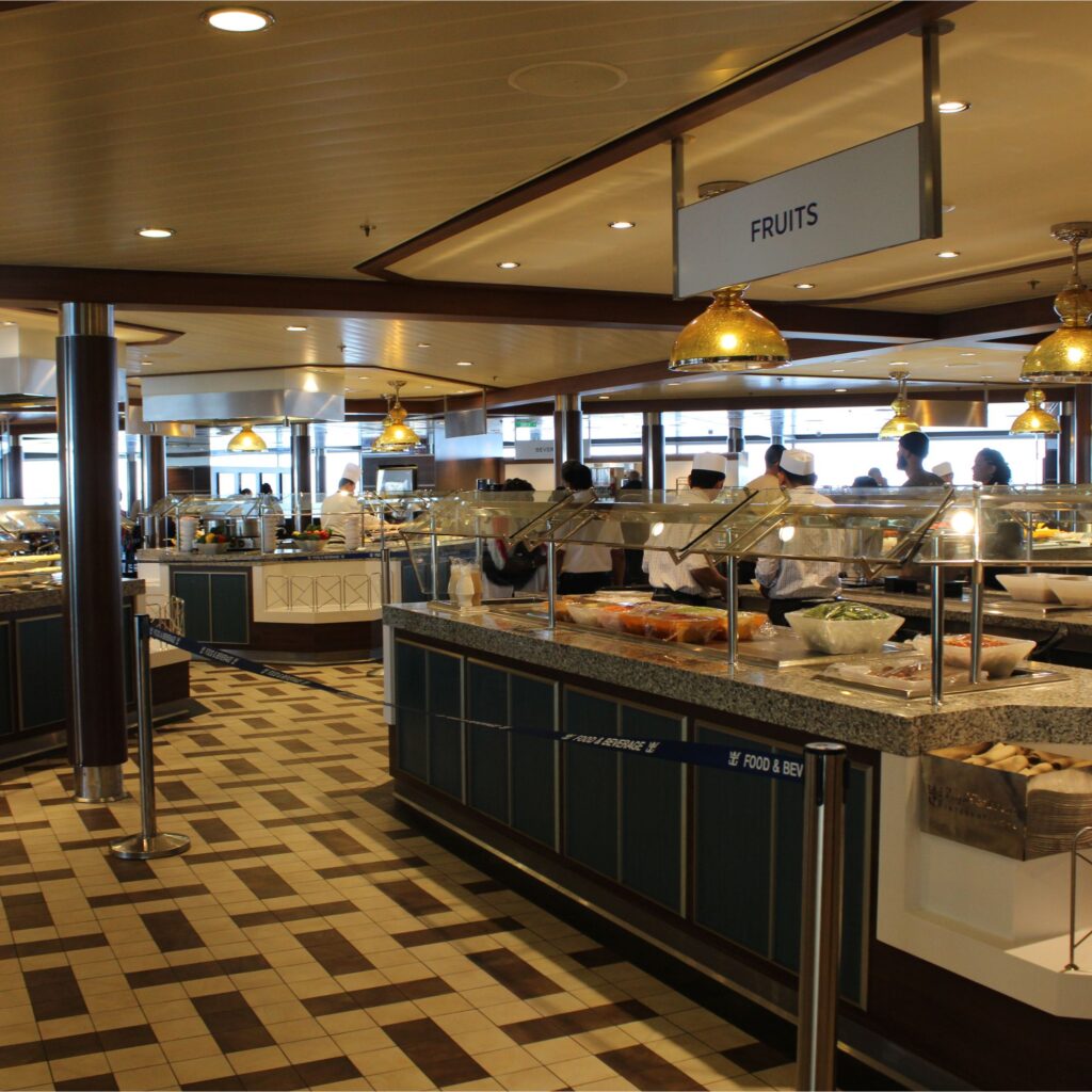 A buffetwith various food stations and staff serving food. The area is well-lit with decorative lighting and has a modern design.