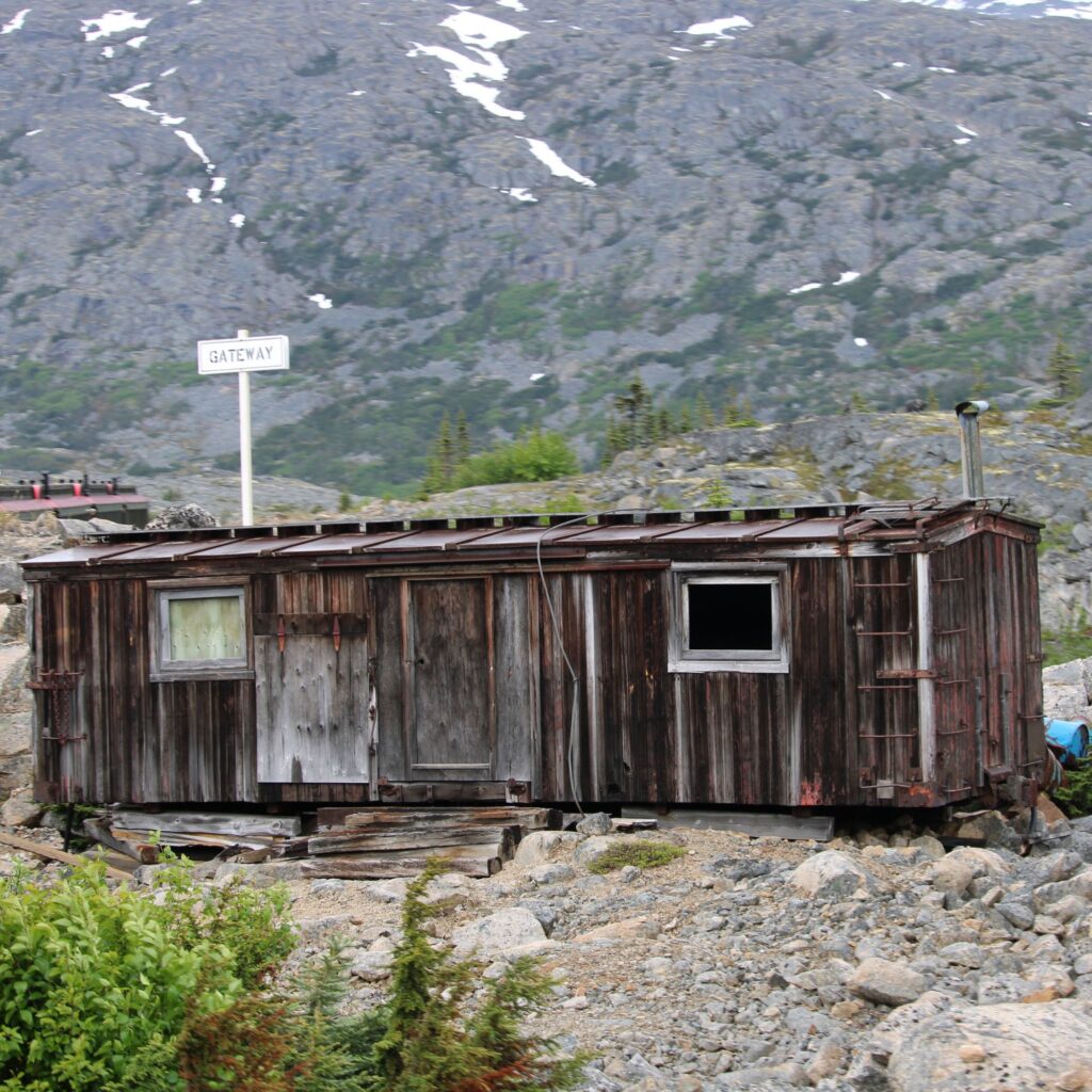 A small shed amidst rocky terrain and greenery.

