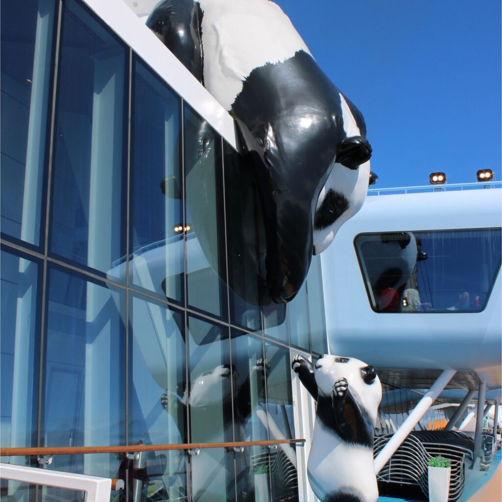 Two large panda sculptures on the exterior of a cruise ship.

